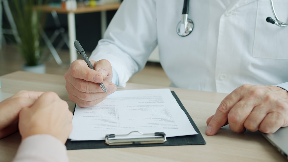Doctor reviewing forms before medical debt reaches credit report collections